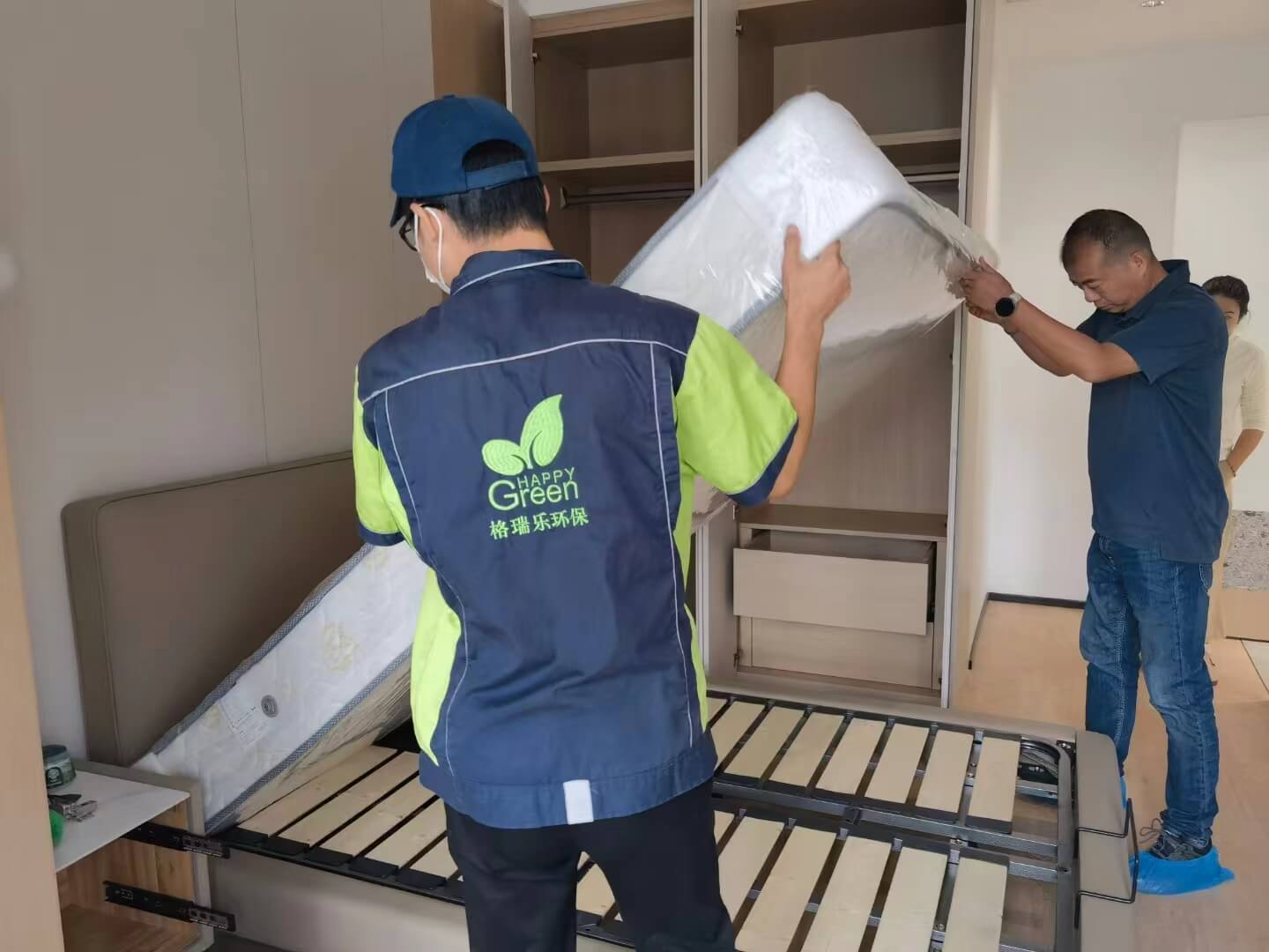 新房门口，格瑞乐家具除甲醛团队合影留念，展示专业服务形象和对成果的自信。