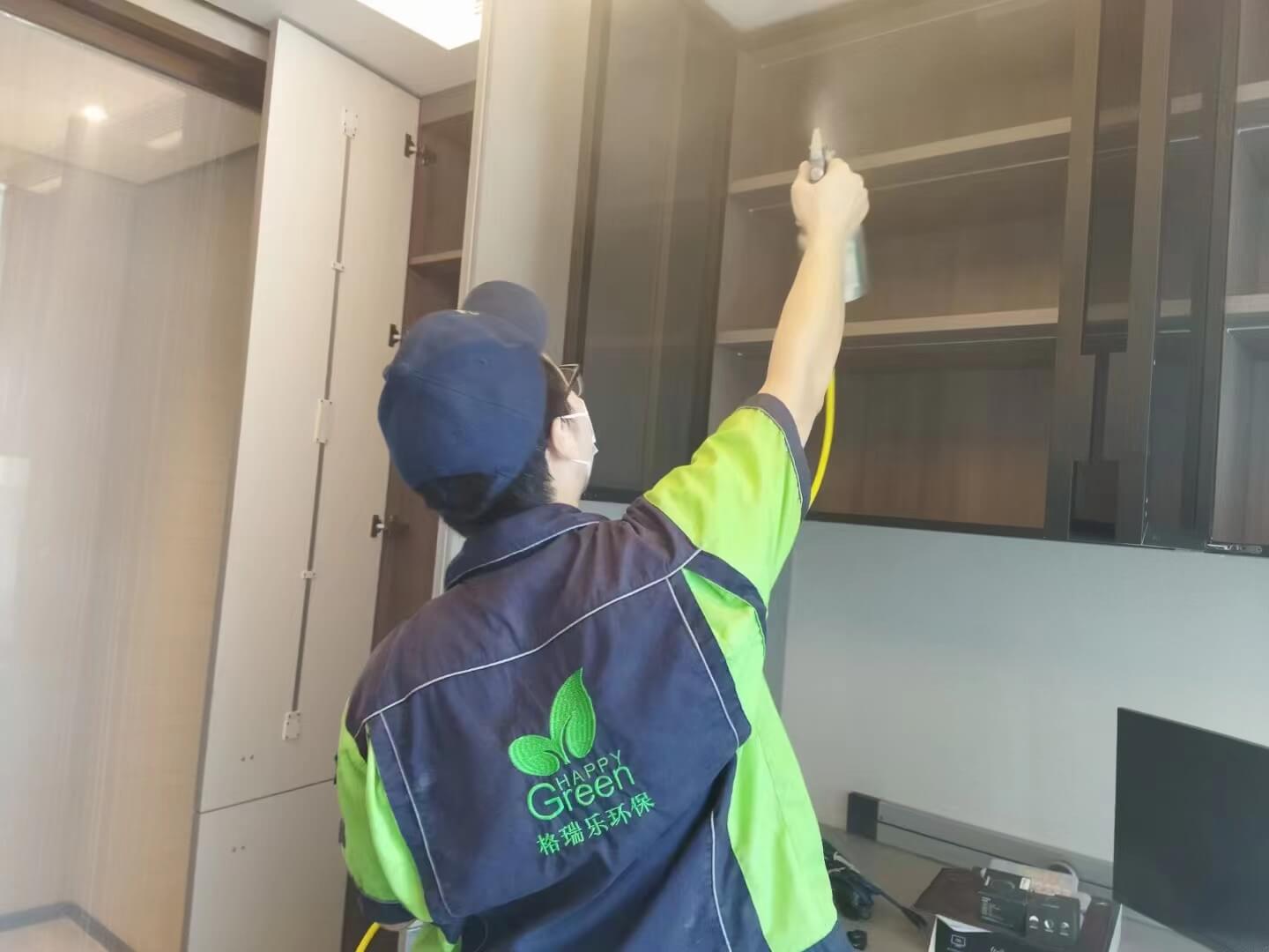 特写书房场景，工作人员将格瑞乐除甲醛吸附包整齐放置在木质书架的每层隔板上，尤其是书籍密集处。