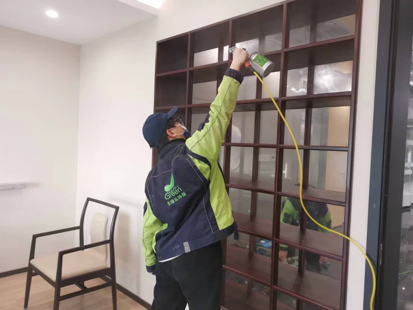 餐厅内，工人正用格瑞乐除甲醛清洁布，用力擦拭实木餐桌的桌面，连细微纹理都不放过。